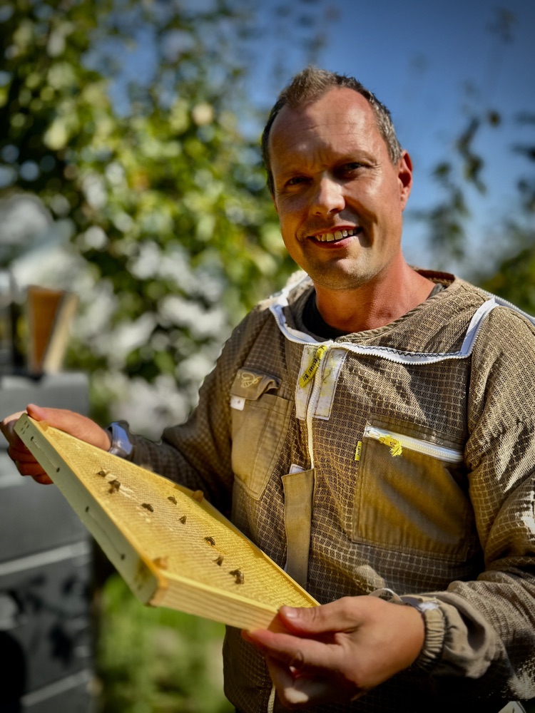 Portræt af biavler Kasper Madvig i bidragt med en bitavle i sin bigård i Sorø